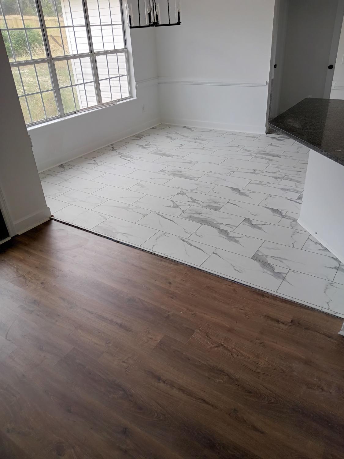 Kitchen area with marble-look tile and LVP transition