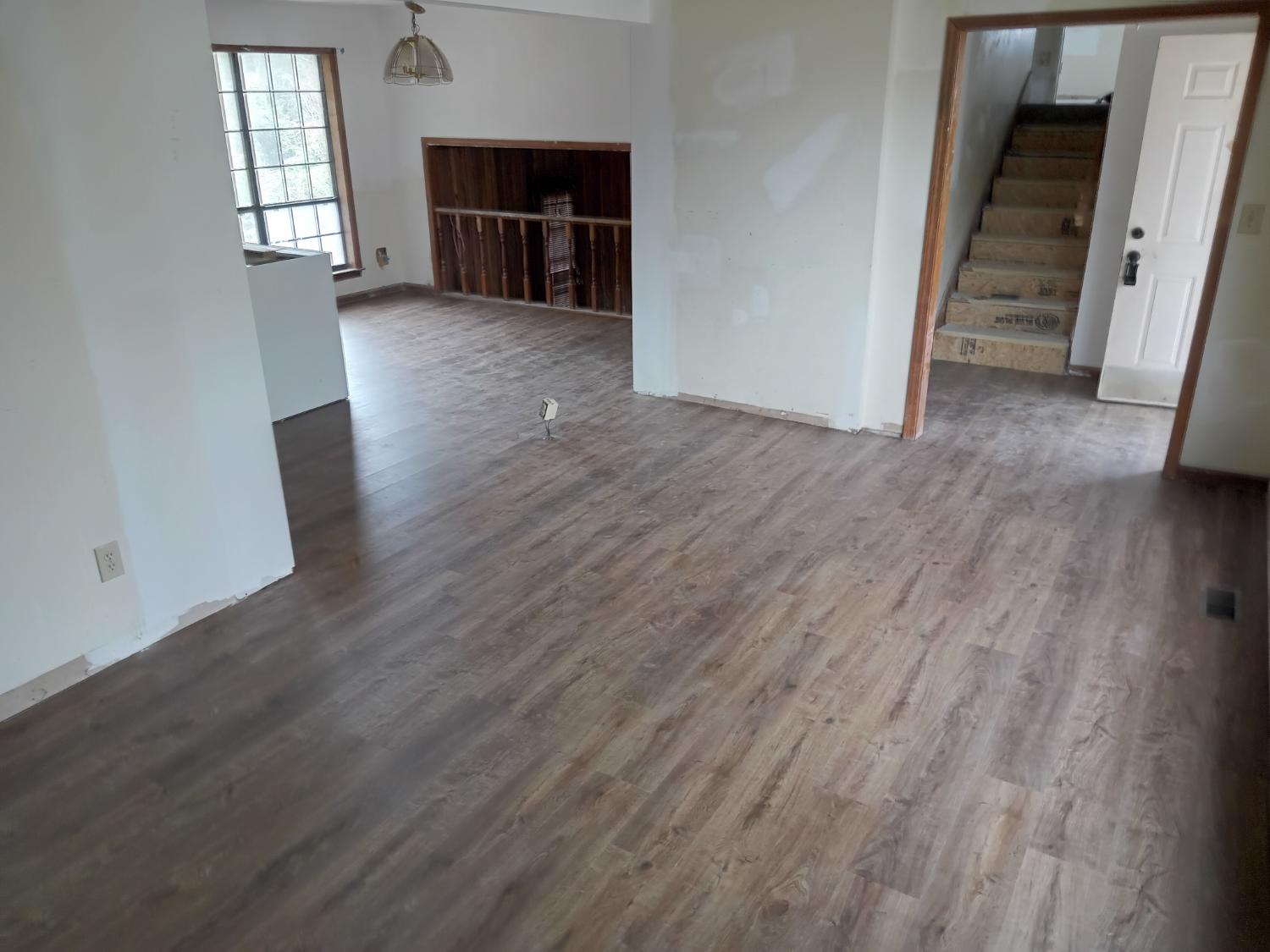 Open living area with medium gray LVP