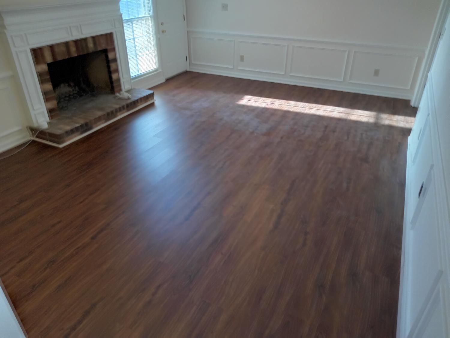 Large living room with dark LVP and fireplace
