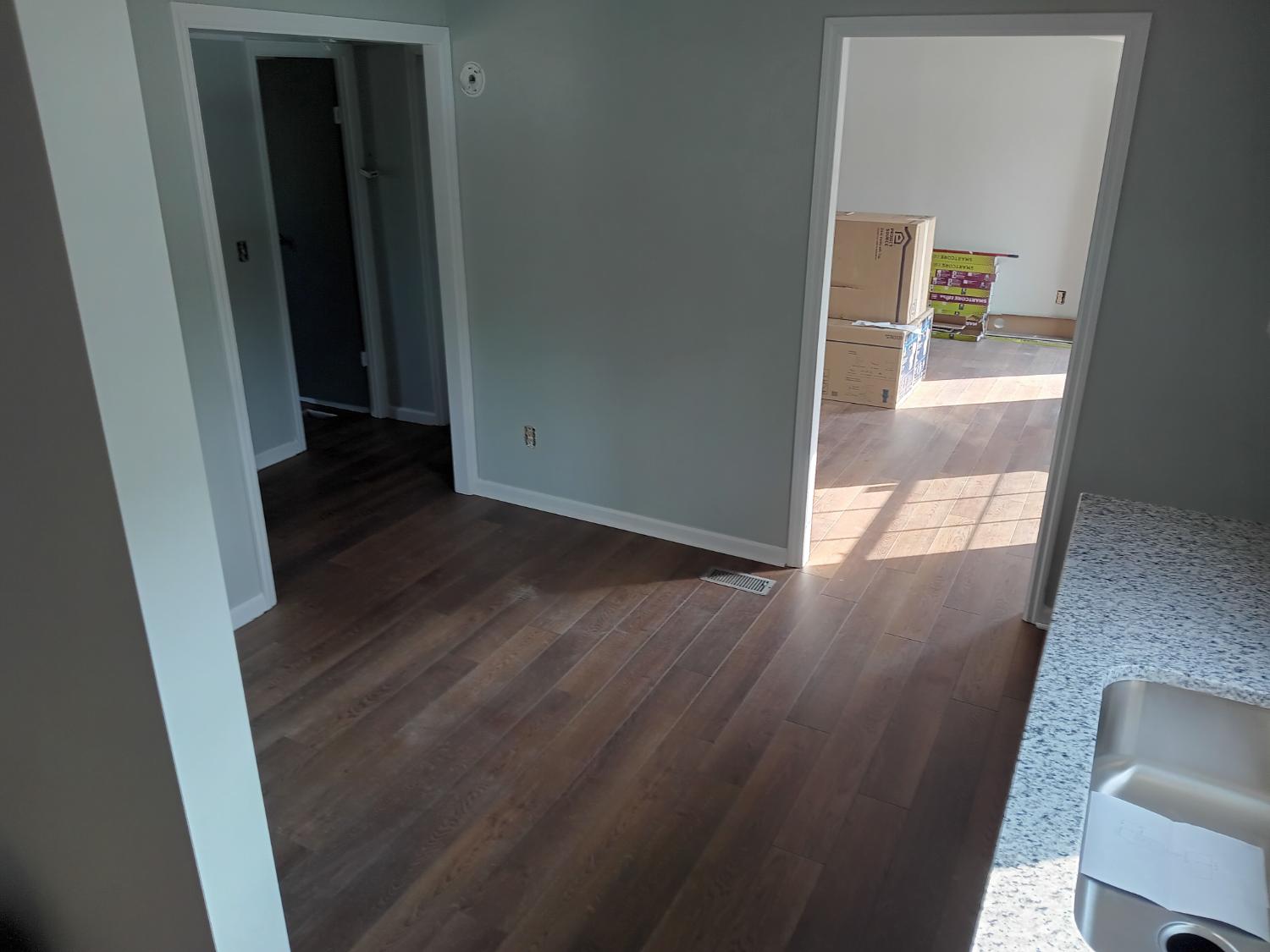 Open rooms with medium brown LVP