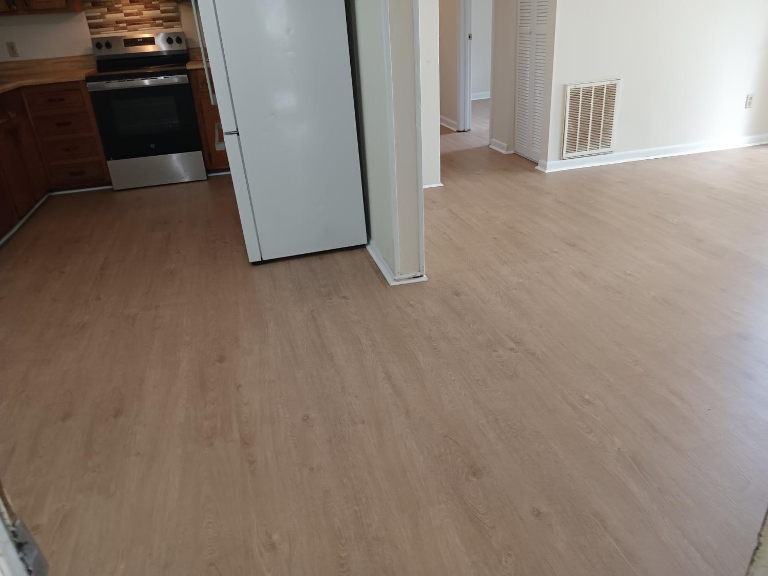 Kitchen and living area with medium tone LVP