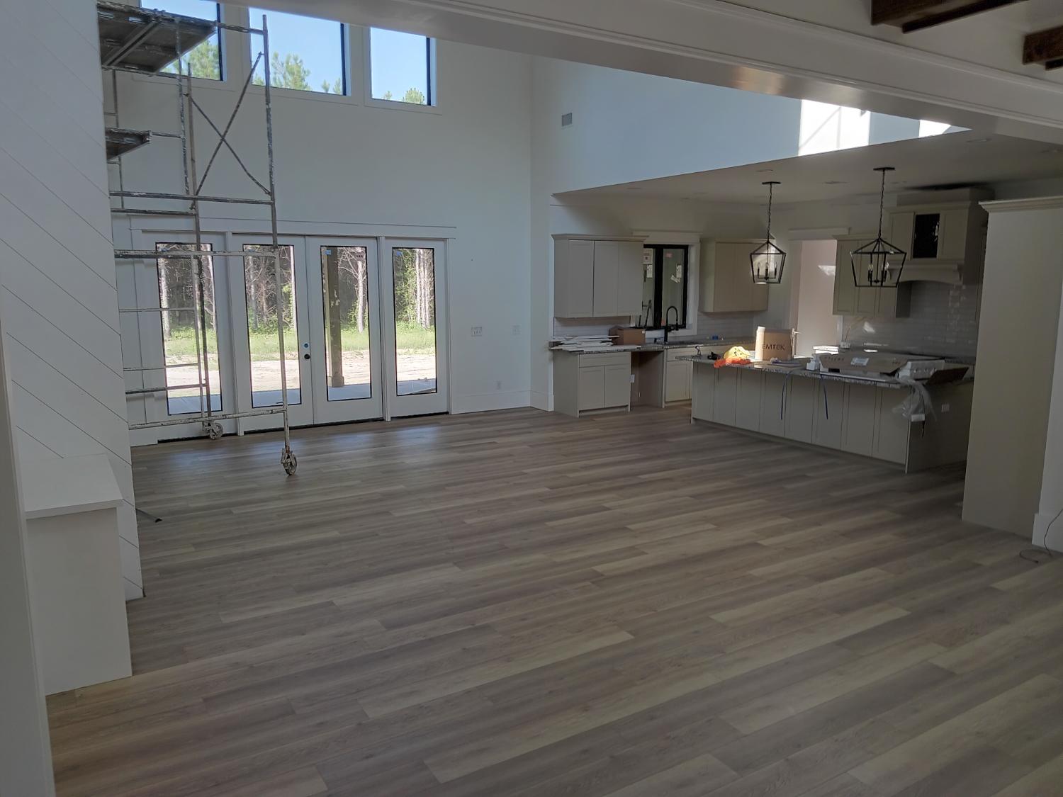 Open concept living and kitchen with light gray LVP flooring